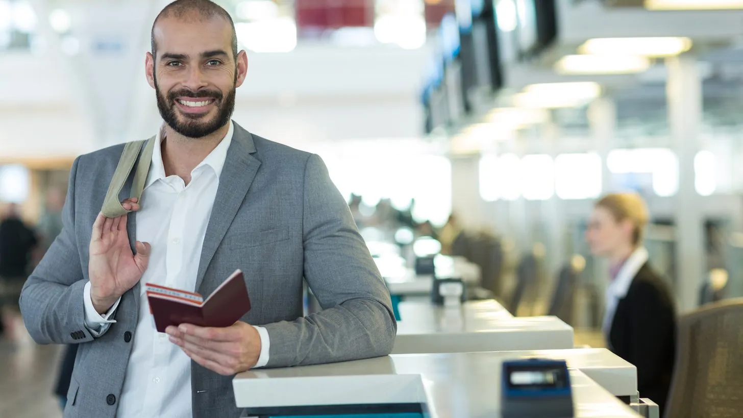 A traveller presenting a passport and boarding pass at an airline check-in counter