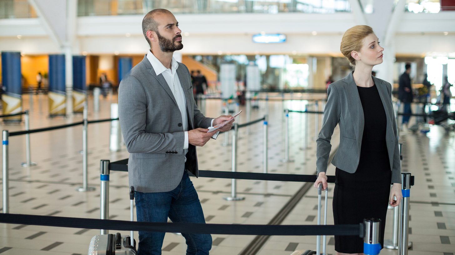 Passengers waiting in a queue at an airport terminal counter