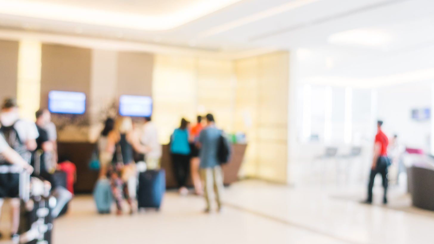Travellers walking through an airport terminal concourse