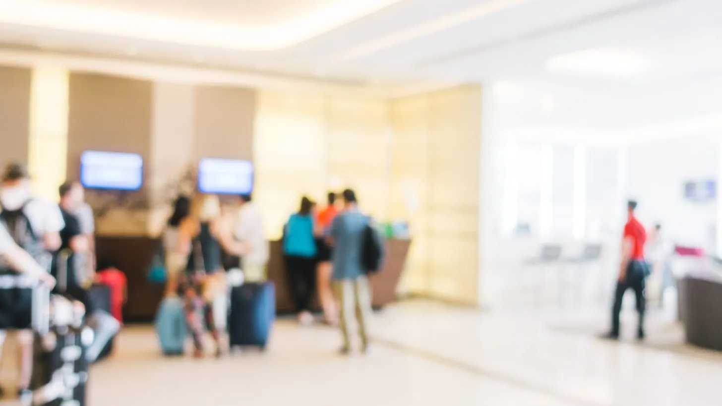 Travellers walking through an airport terminal concourse