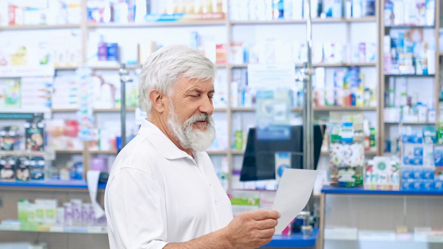 A traveller reading a prescription at a pharmacy counter