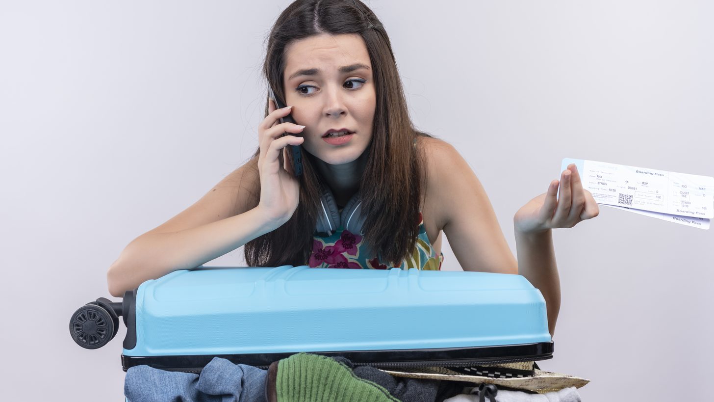 A traveller making a phone call while holding travel documents