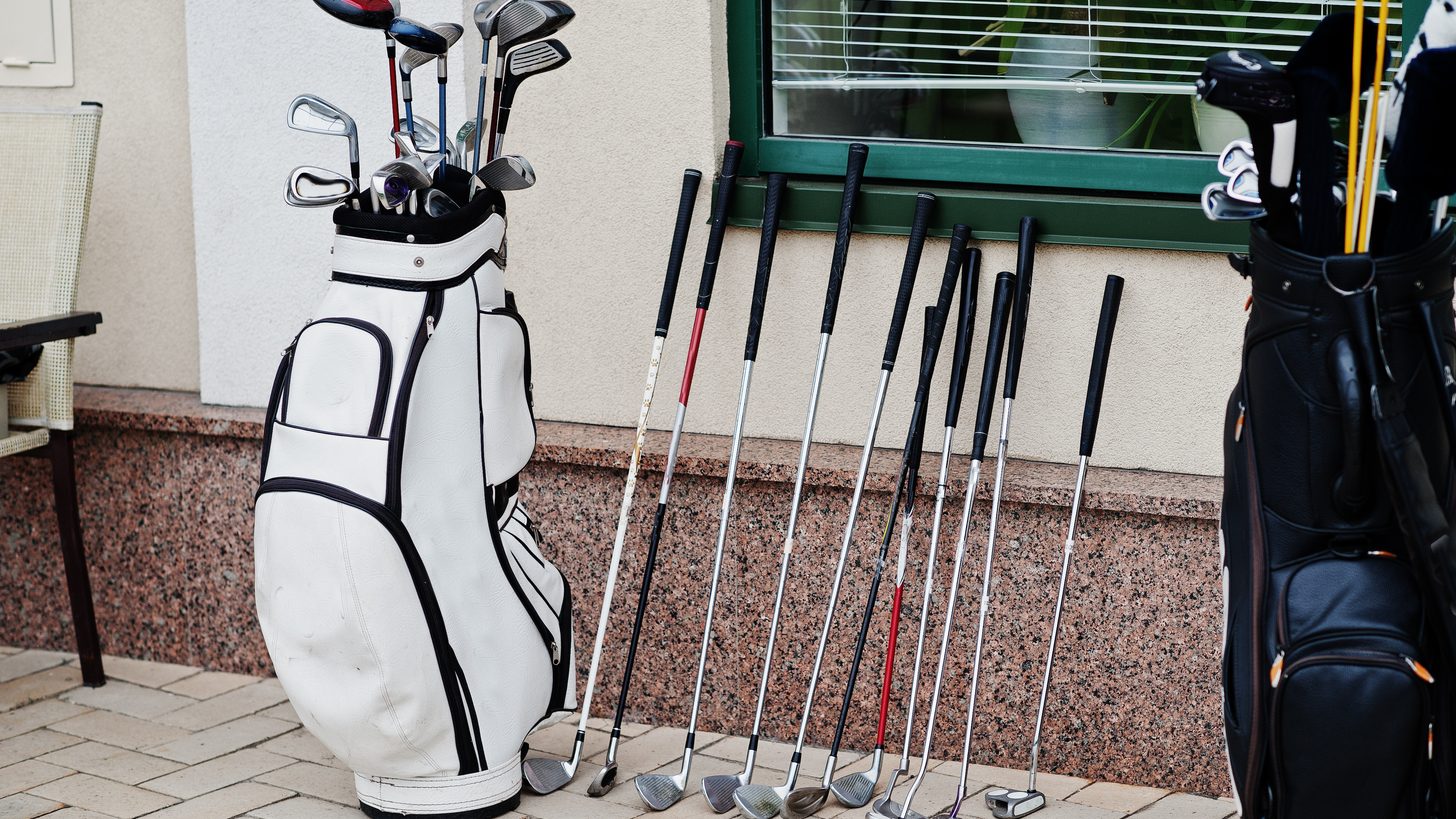 A set of golf clubs in a travel bag being handled at an airport