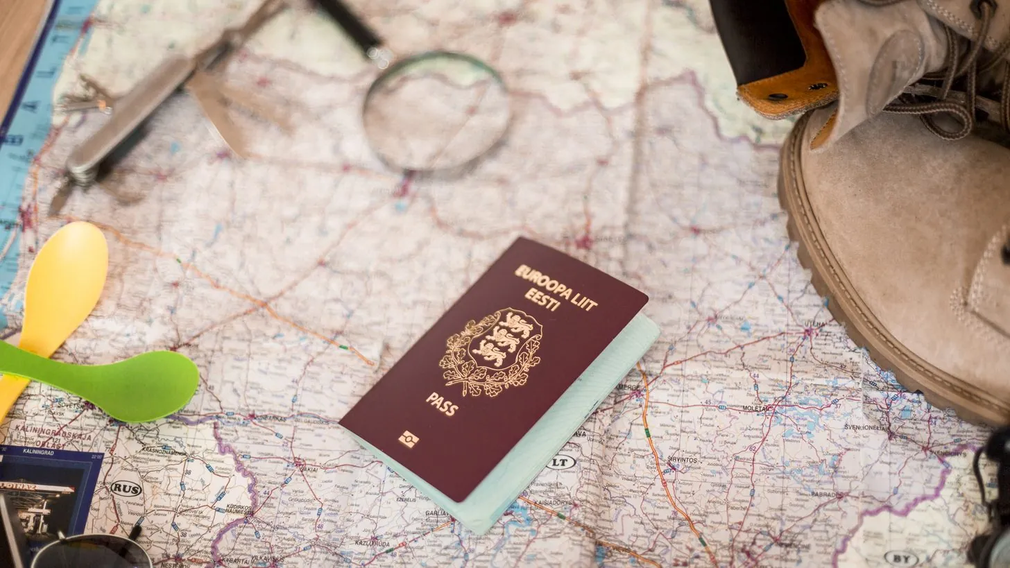 Ein Reisepass und Reiseunterlagen liegen auf einer Landkarte