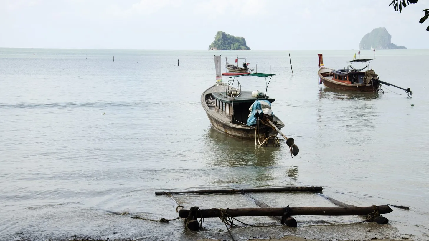 乗船を待つ旅行者が並ぶ、南国の島の桟橋に停泊した旅客フェリー