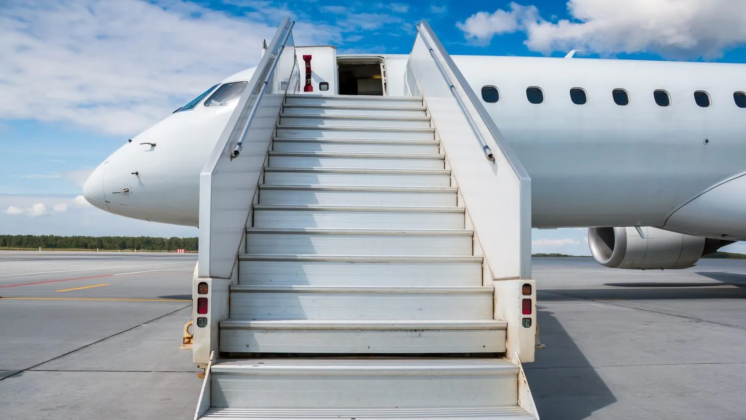 ボーディングステップを付けた地方空港のエプロンに駐機する旅客機