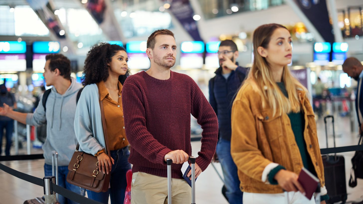 Travellers moving through an airport departures area