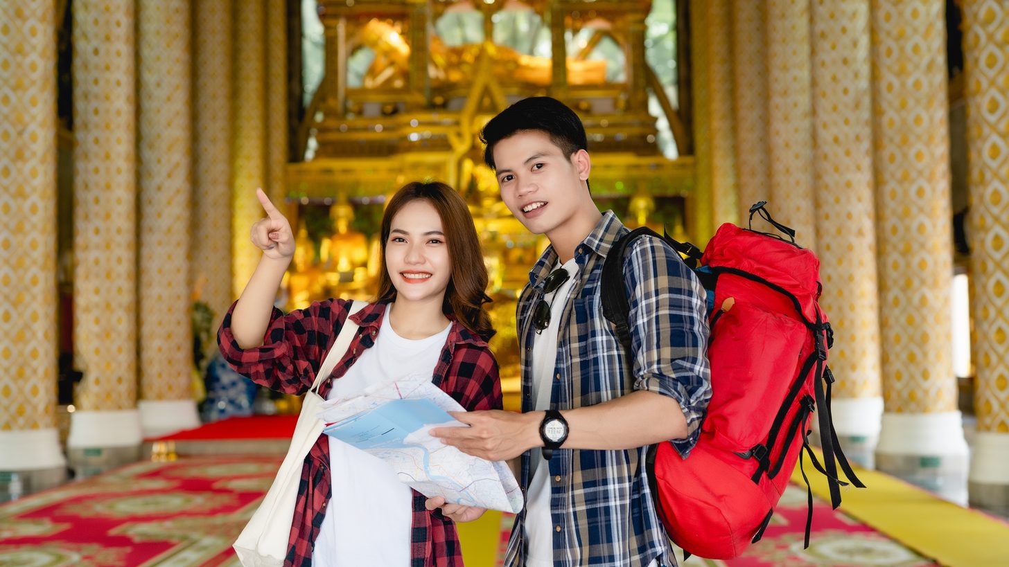 A tour guide holding documents while briefing a small group of travellers