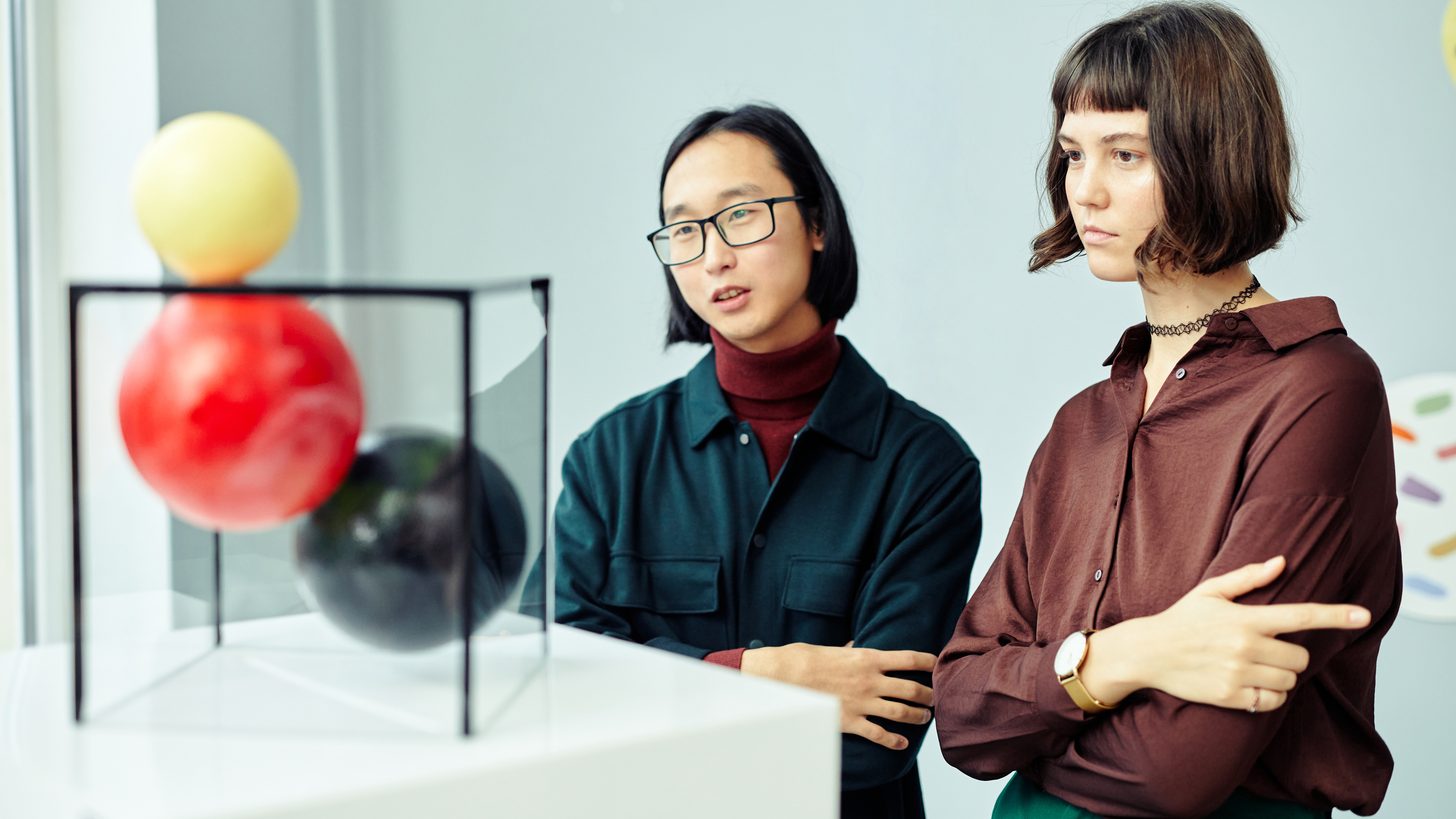 Gallery visitors standing in front of a large installation