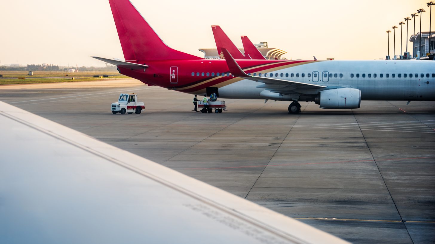 An aircraft at an airport with the sun low behind it