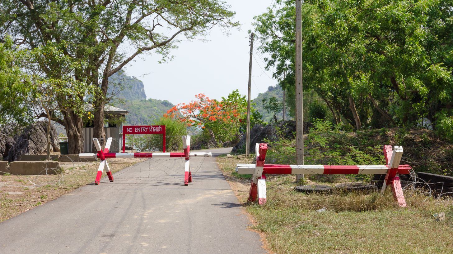 A no-entry sign and roadblock closing a road
