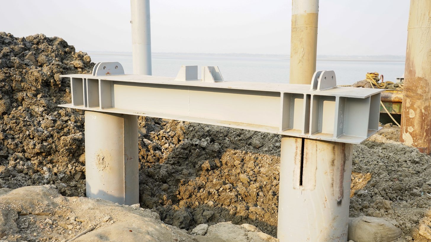 Steel beams being installed on piles at a construction site
