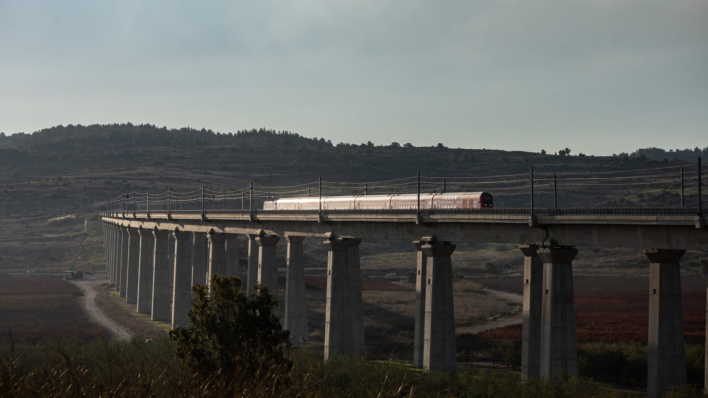 A train on a railway line with greenery alongside