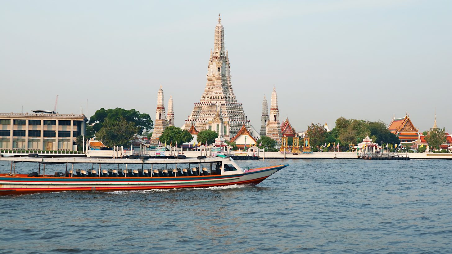 A public river express boat passing Wat Arun on the Chao Phraya in daylight