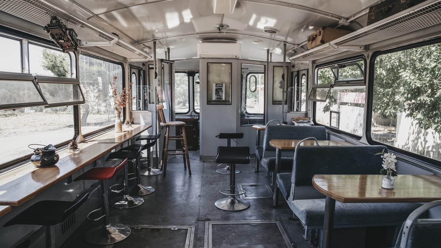 The interior of an old railway carriage converted into a cafe, with booth seating and tables