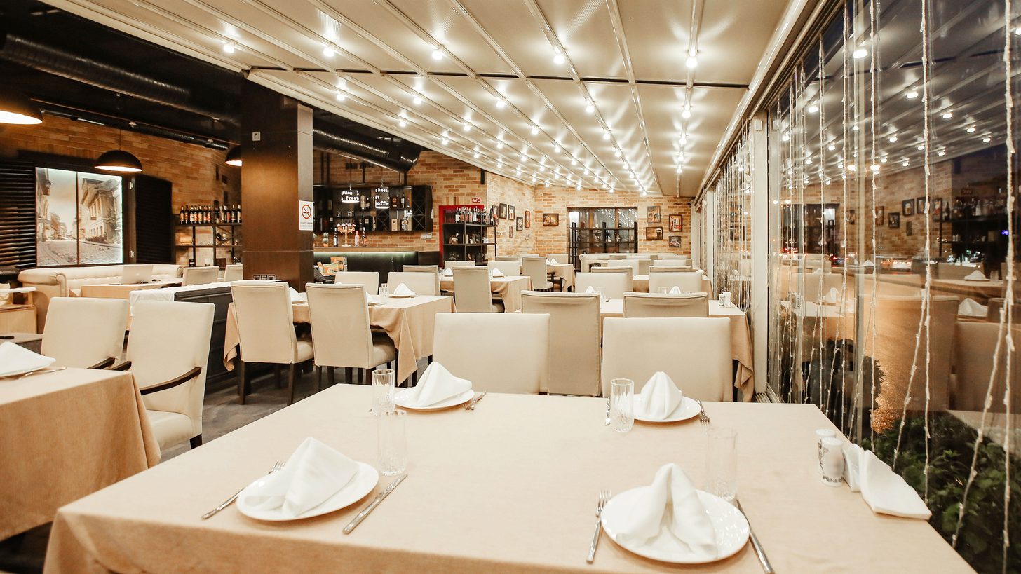 An empty hotel restaurant with tables laid and no diners