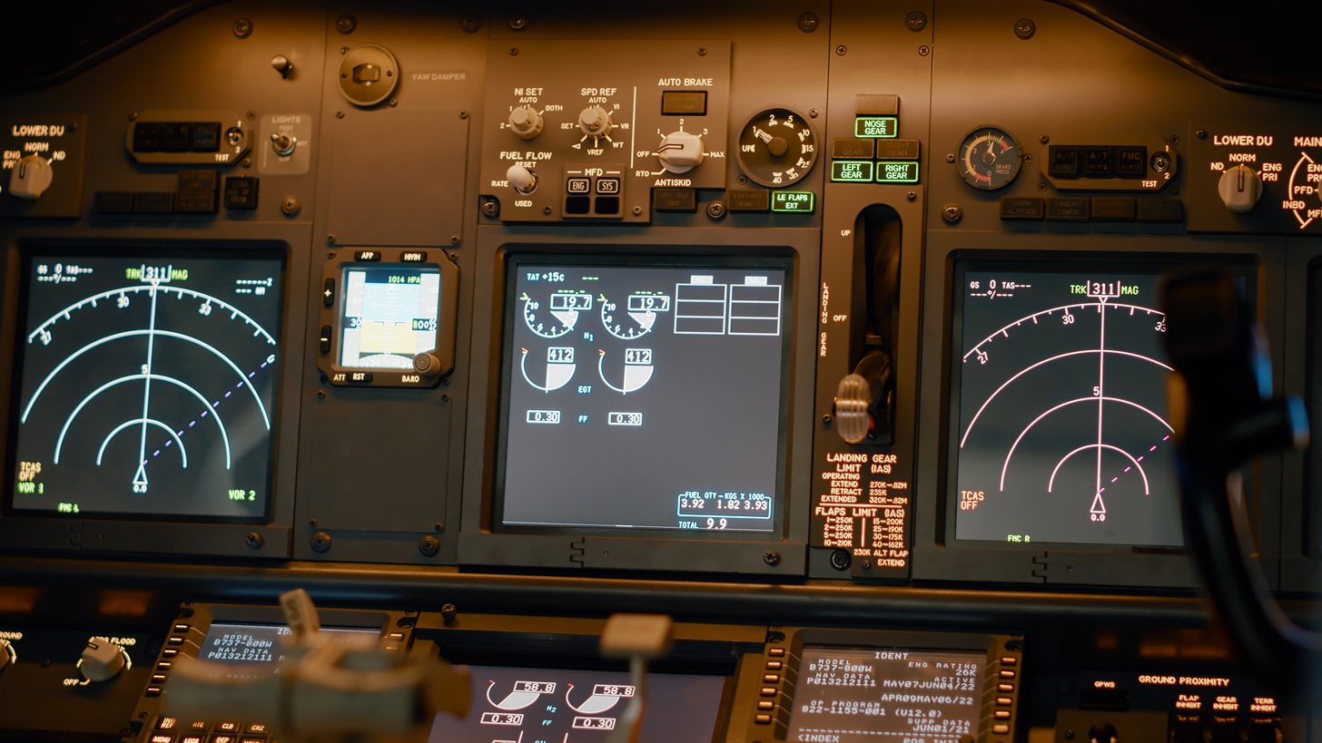 The instrument panel of a Boeing 737-800 flight deck showing navigation displays and engine readouts