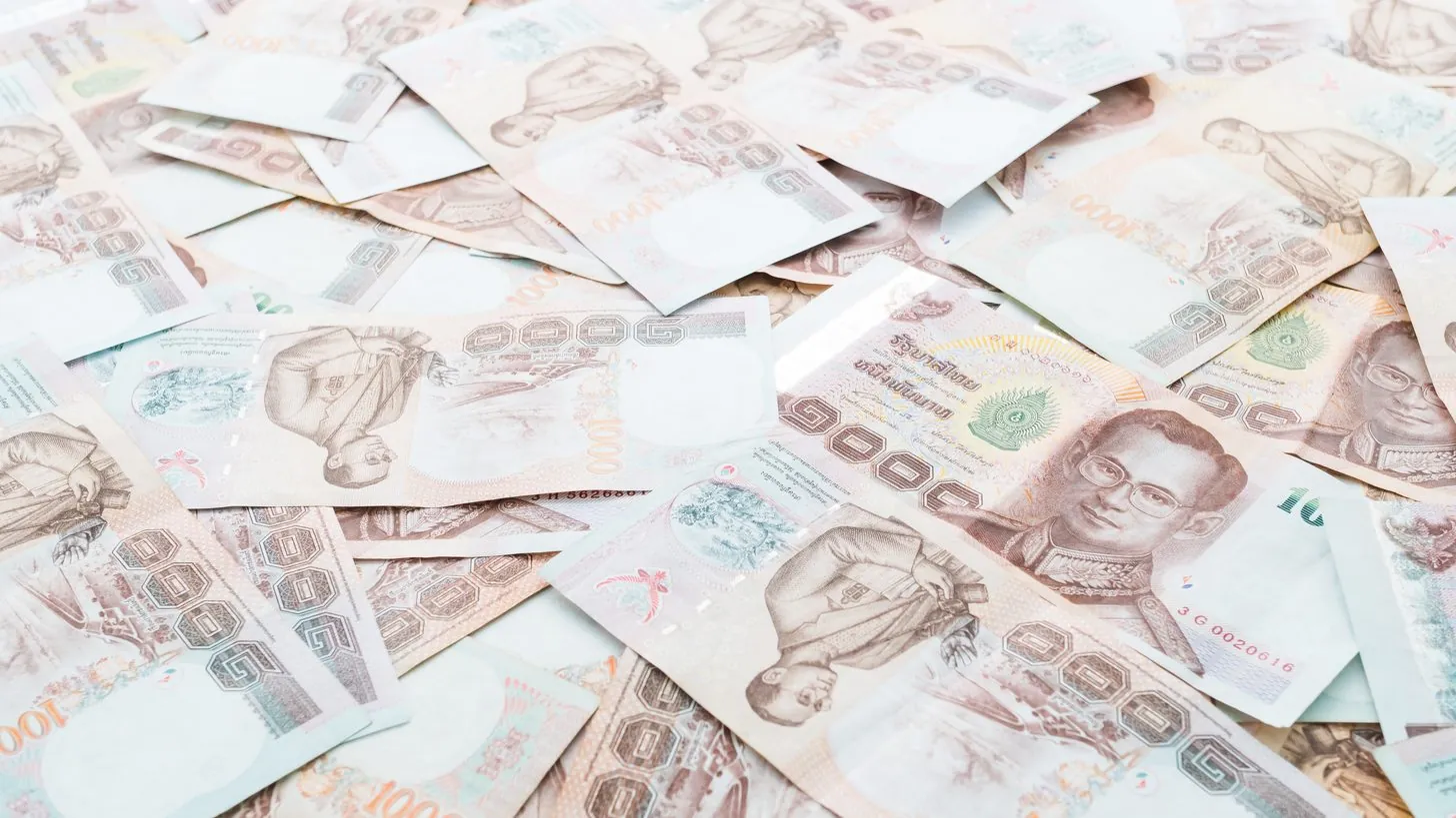 Thailändische Tausend-Baht-Banknoten, auf einer Fläche ausgebreitet