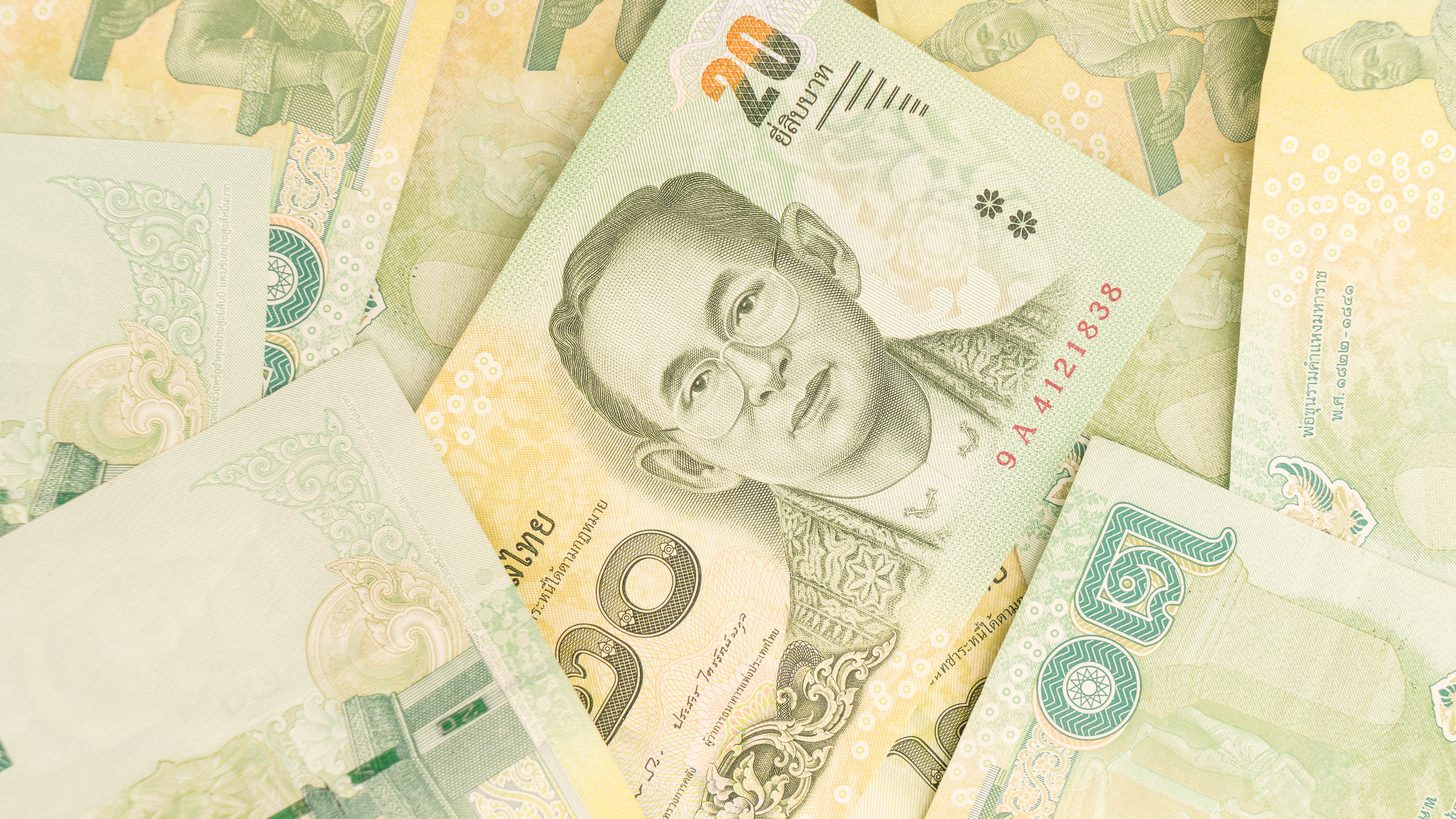Primer plano de billetes de baht tailandés apilados