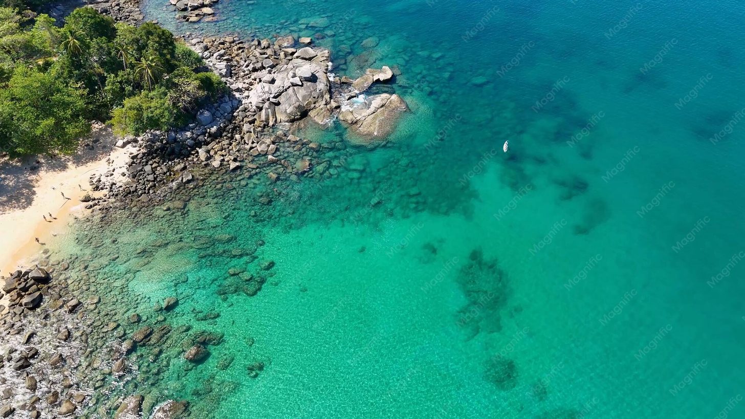 Luftaufnahme von türkisfarbenem Wasser und felsiger Küste am Strand Laem Singh auf Phuket, Thailand