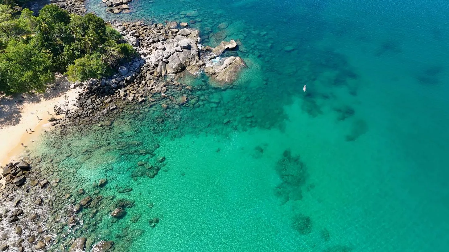 タイ・プーケットのレムシンビーチ、ターコイズの海と岩の多い海岸線を上空から撮影した写真