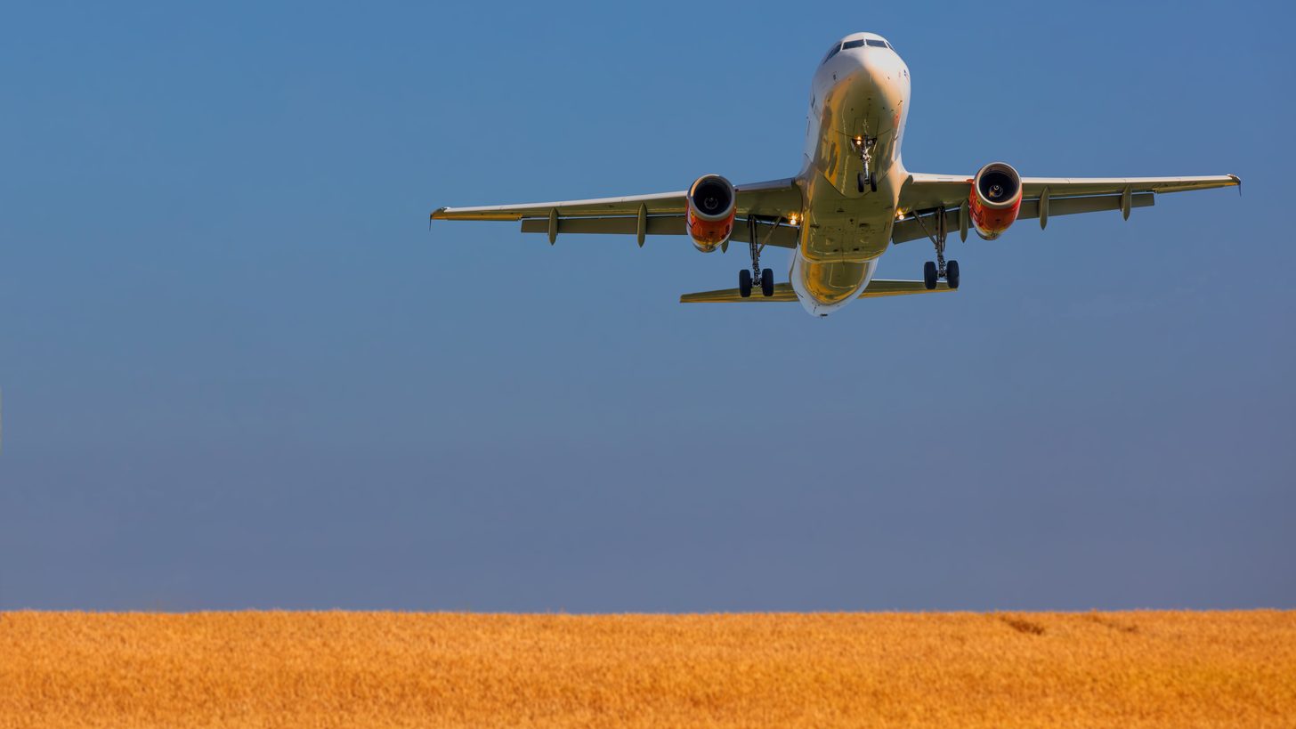Ein weißes Passagierflugzeug im Flug vor klarem Himmel