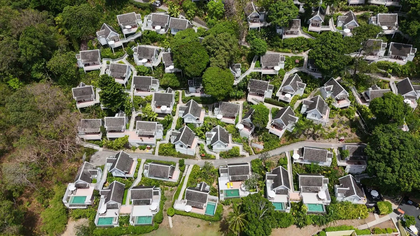 緑の斜面に建つプライベートプール付きリゾートヴィラの空撮