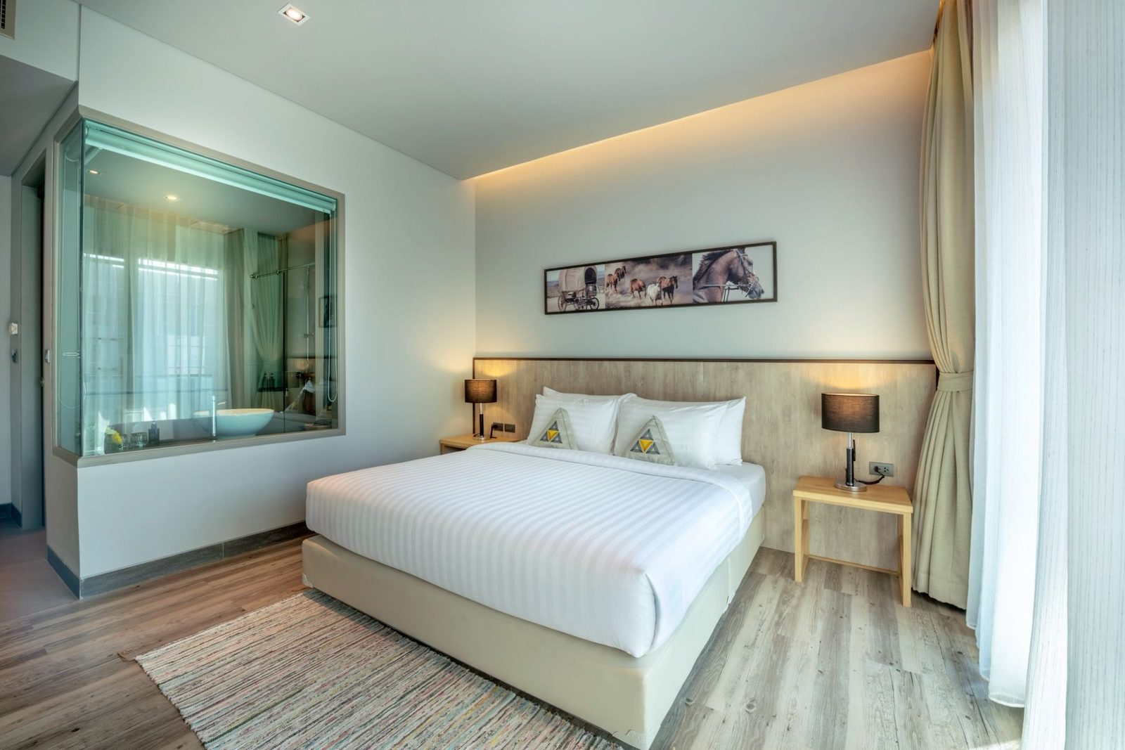 Guest room with king bed and glass-walled bathroom at AISANA Hotel Korat