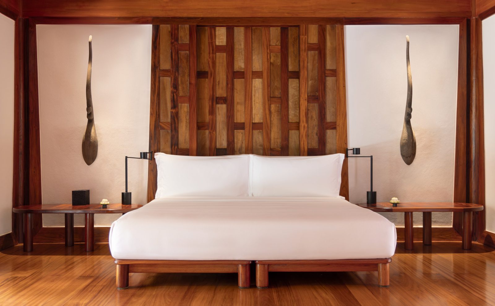 King bed and wood-panelled wall in a Pavilion bedroom at Amanpuri
