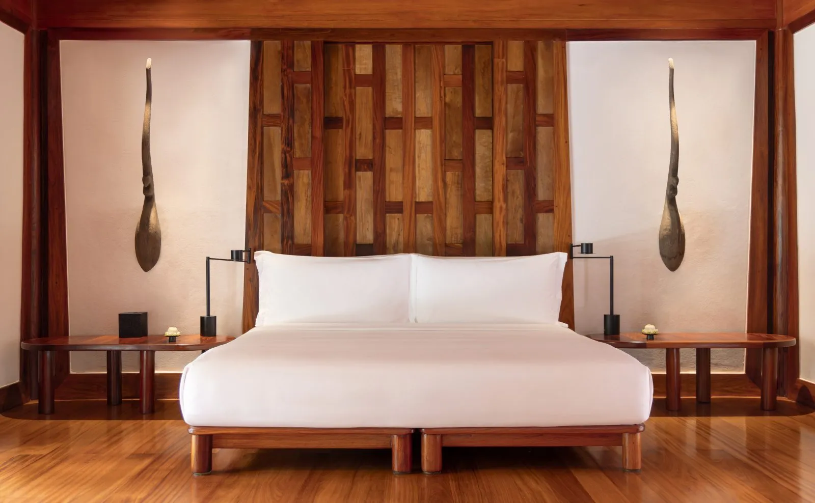 King bed and wood-panelled wall in a Pavilion bedroom at Amanpuri