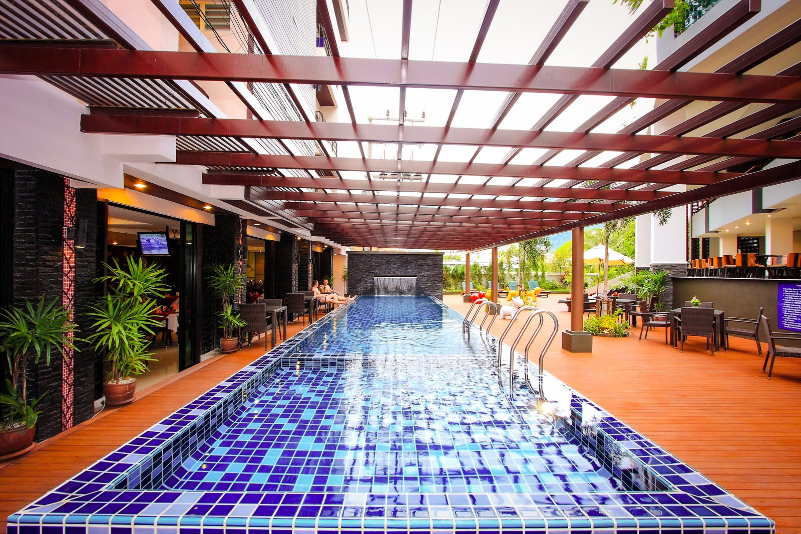 Ground-floor lap pool under a pergola at Andakira Hotel Patong