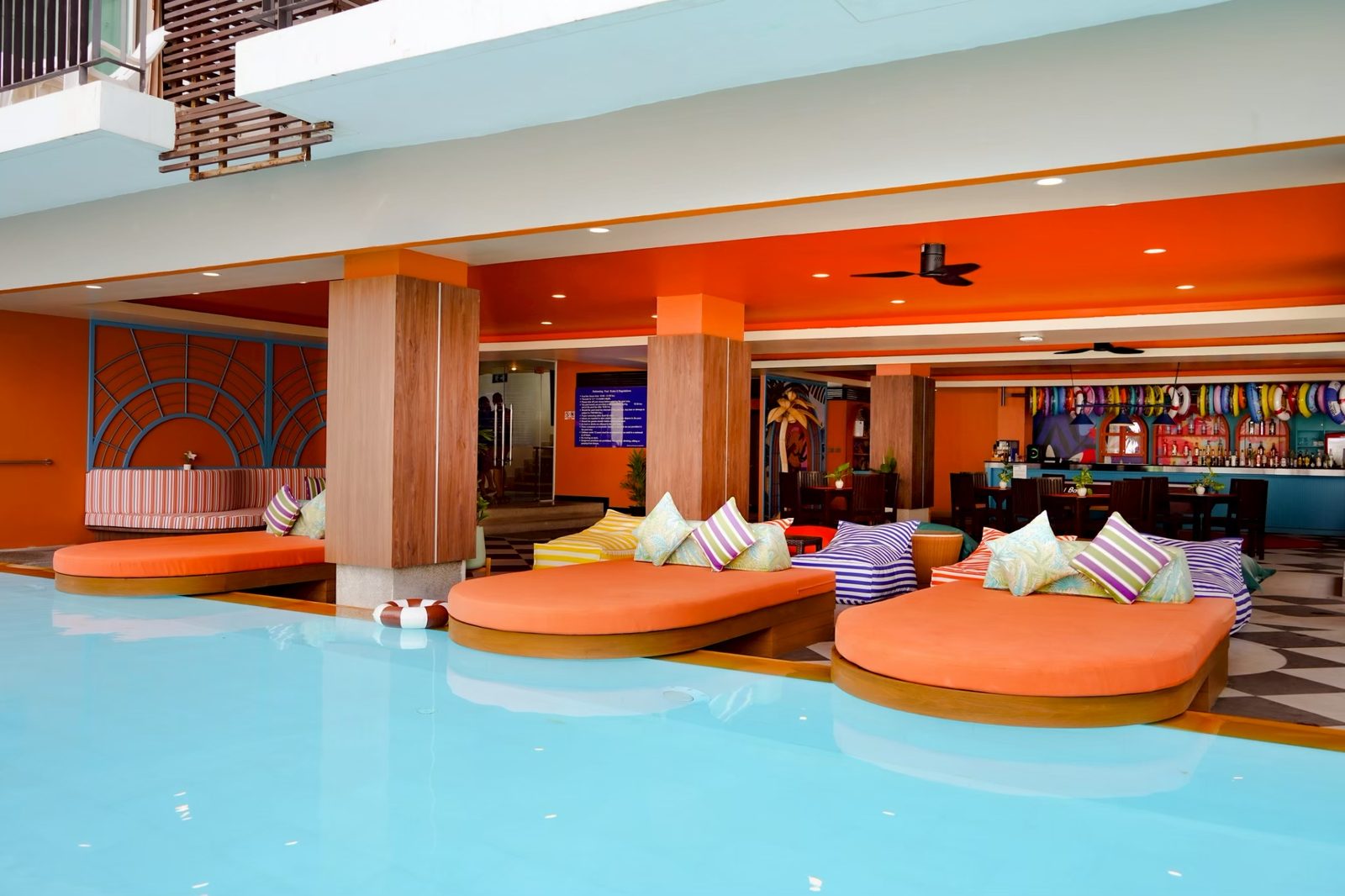 Third-floor swimming pool with day beds and bar at Andakira Hotel Patong
