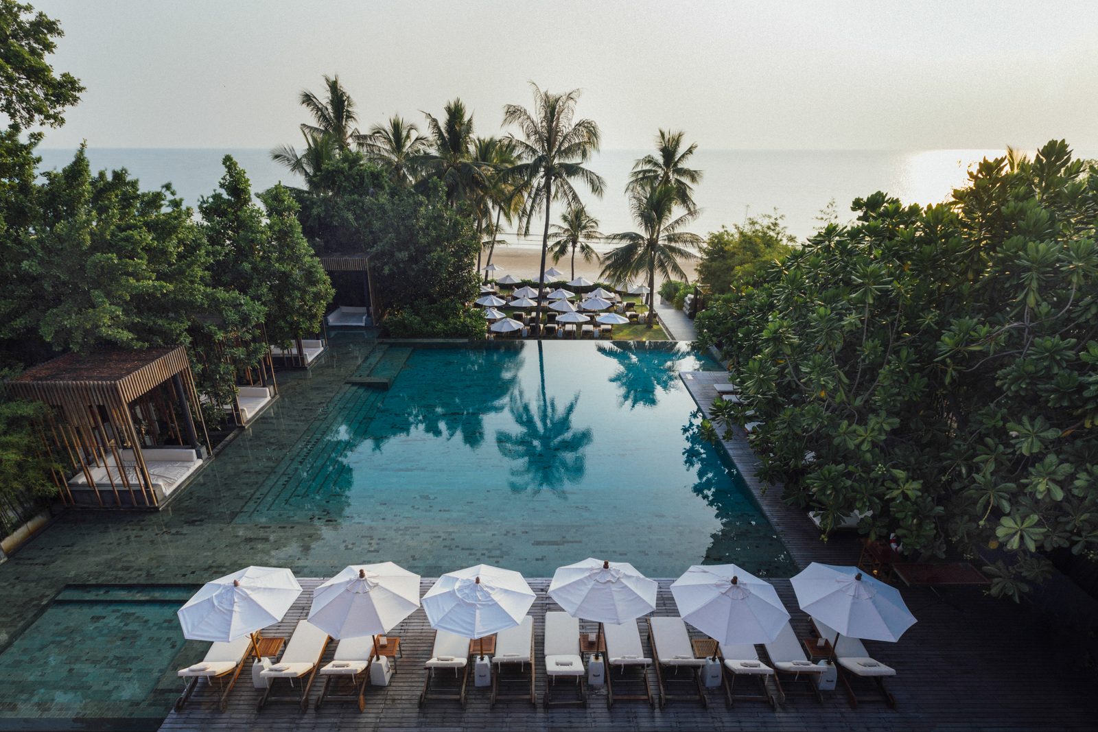 Swimming pool with sun loungers leading to the beach at Cape Nidhra Hotel, Hua Hin