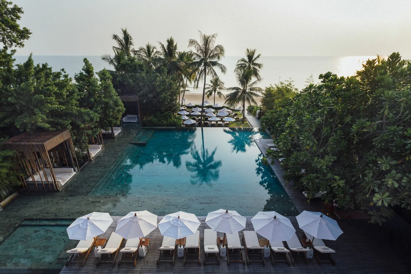 Swimming pool with sun loungers leading to the beach at Cape Nidhra Hotel, Hua Hin