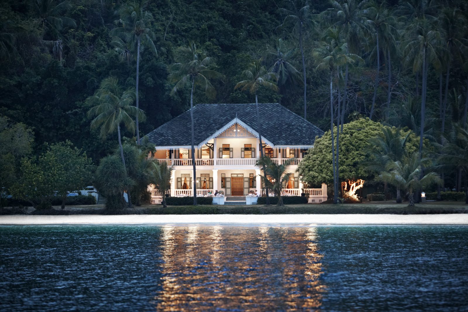 Panwa House Thai restaurant lit up at night by the water at Cape Panwa Hotel, Phuket