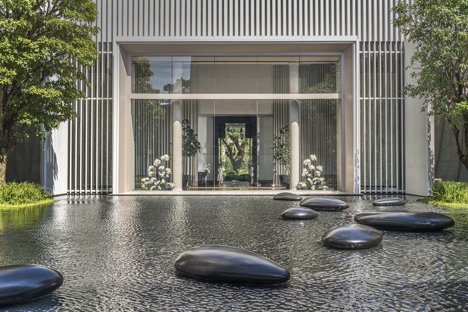 Arrival courtyard with a reflecting pool and stepping stones at Four Seasons Hotel Bangkok