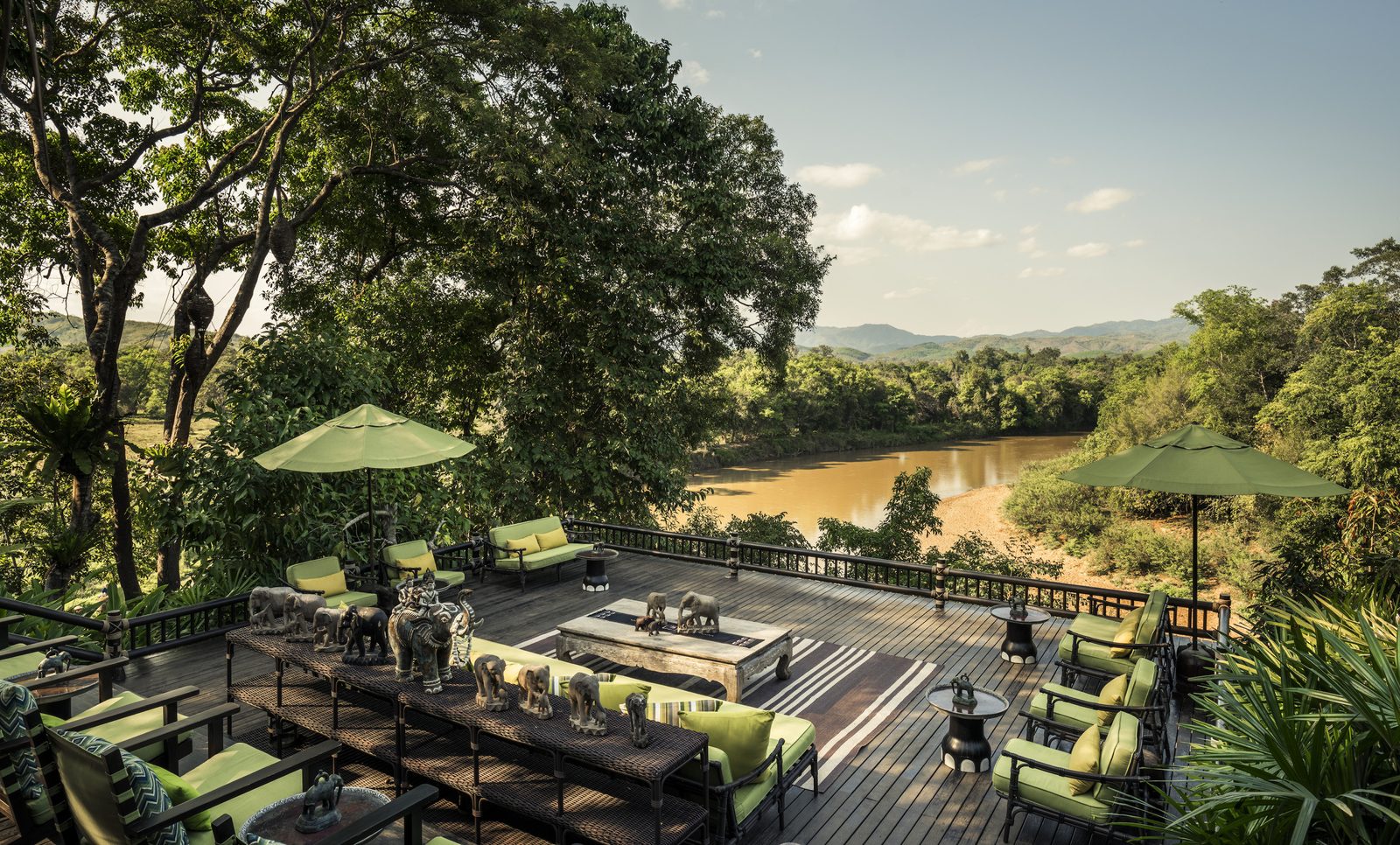 Open-air deck with sofas above the river at Four Seasons Tented Camp Golden Triangle