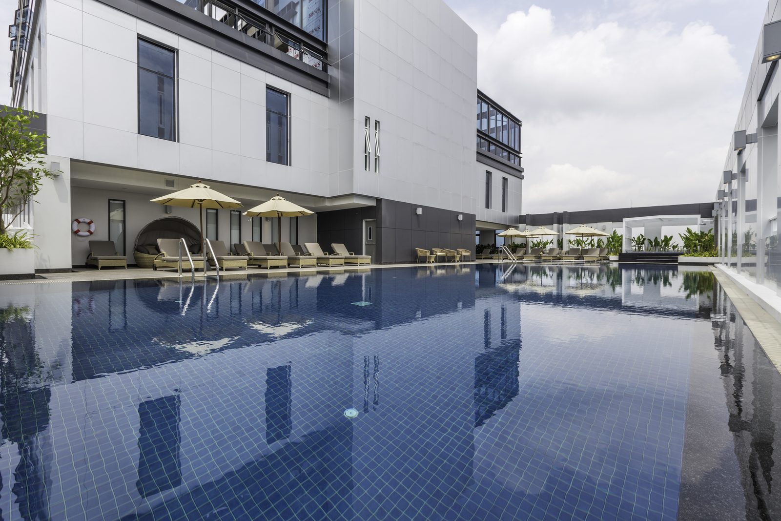 Swimming pool with sun loungers between the wings of Kantary Hotel, Korat