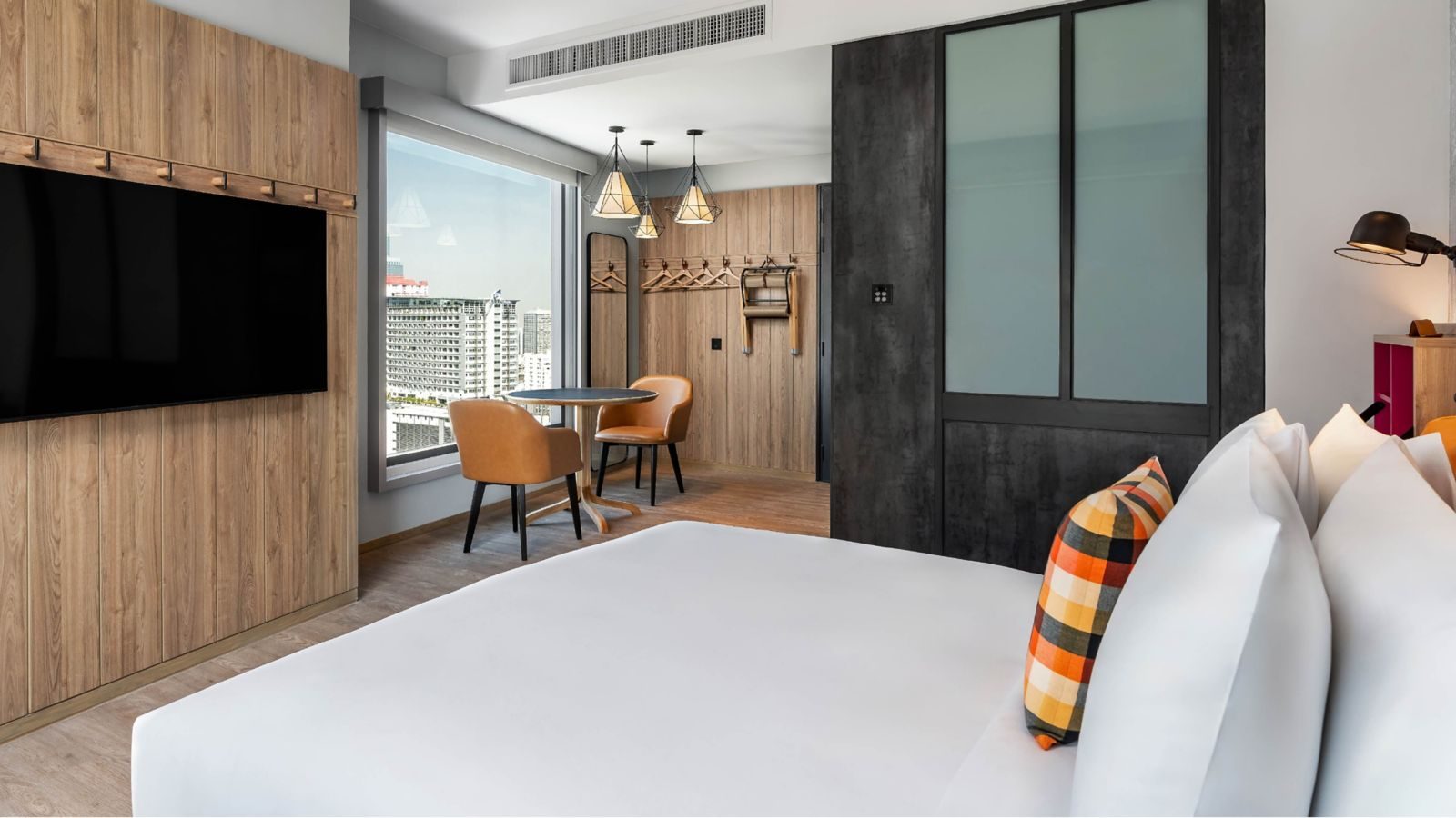 Queen Corner Room with window and table at Moxy Bangkok Ratchaprasong
