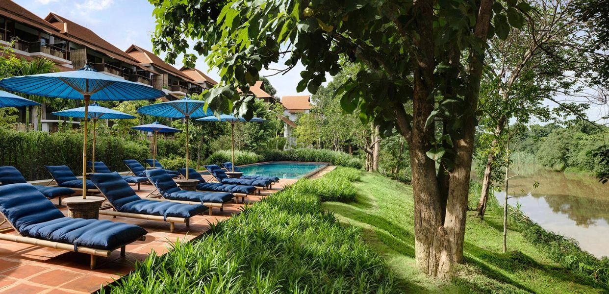 Swimming pool and loungers beside the Ping River at Raya Heritage, Chiang Mai