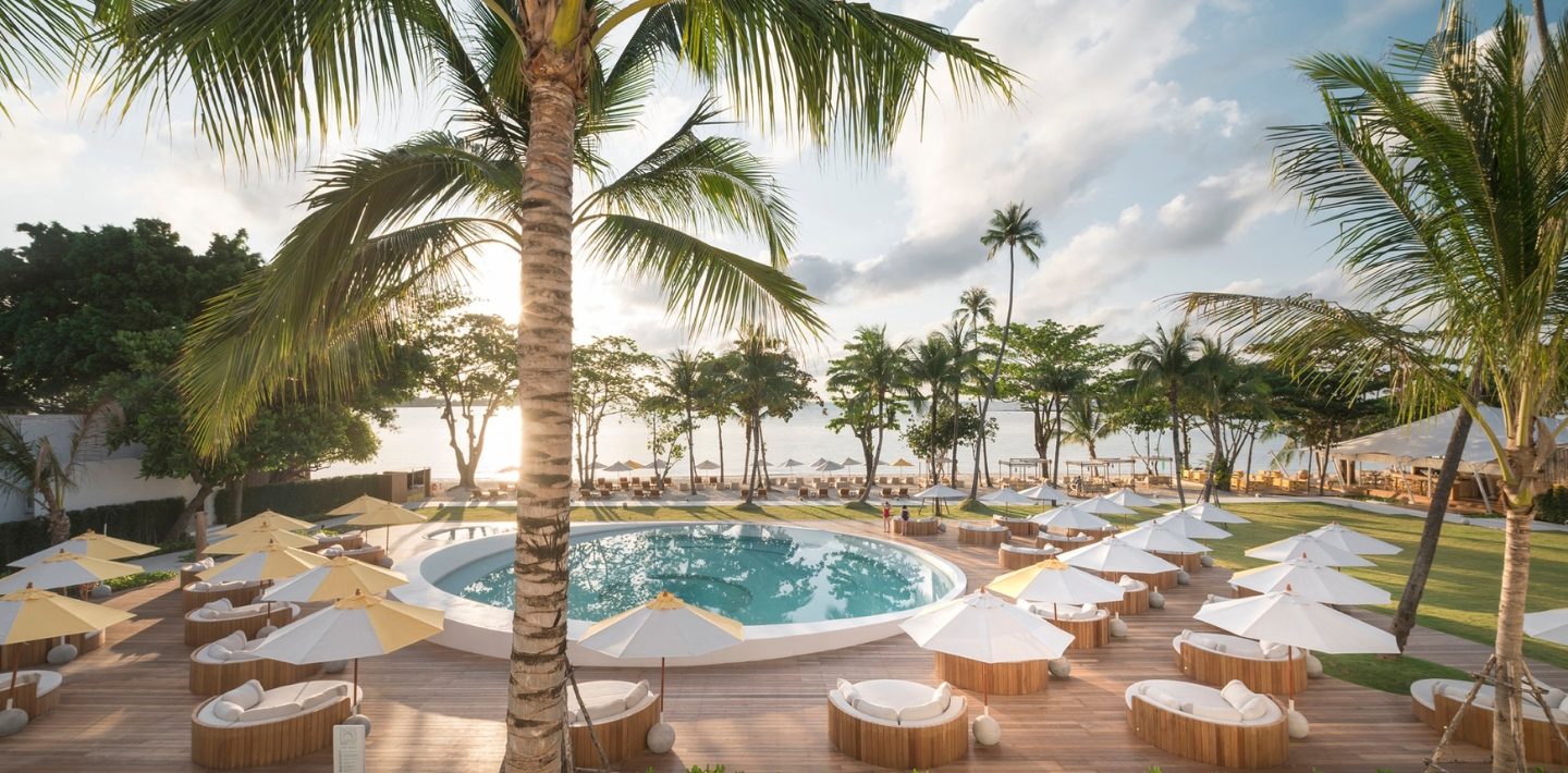 Main pool and loungers under palms by the sea in the Oceanfront Wing of SALA Samui Chaweng Beach Resort