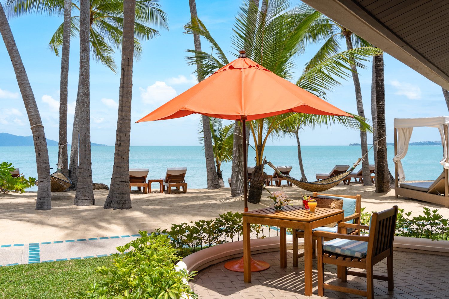 Deluxe Beachfront Villa terrace with a parasol looking over the beach and the Gulf of Thailand at Santiburi Koh Samui