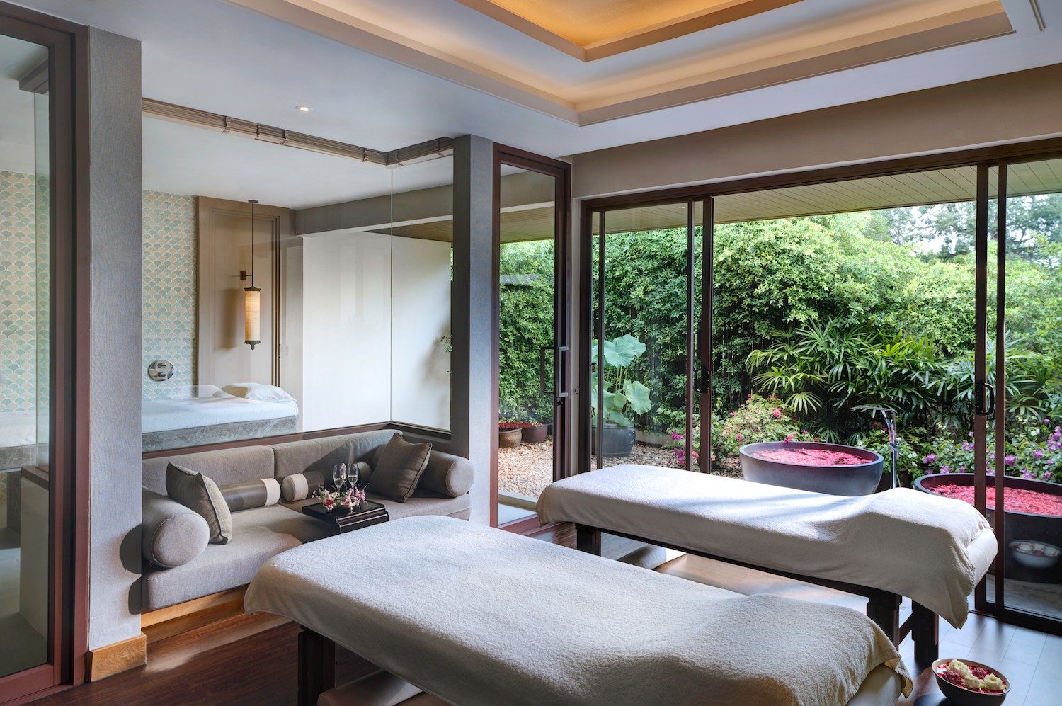 Spa treatment suite with twin massage beds and a garden view at Santiburi Koh Samui