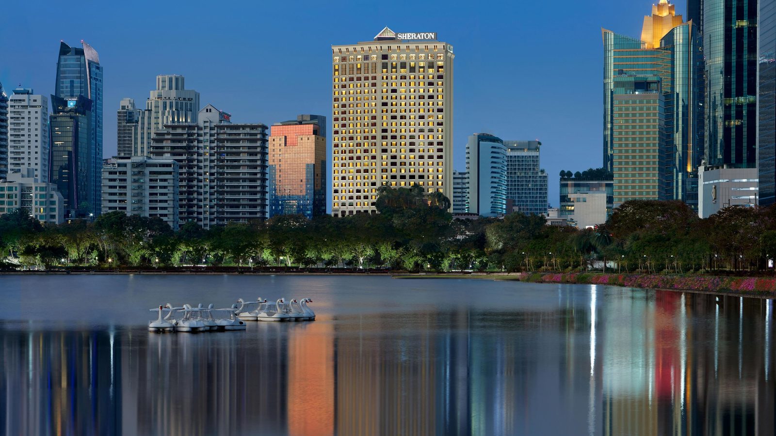 Sheraton Grande Sukhumvit tower seen across Lake Ratchada at dusk, Bangkok