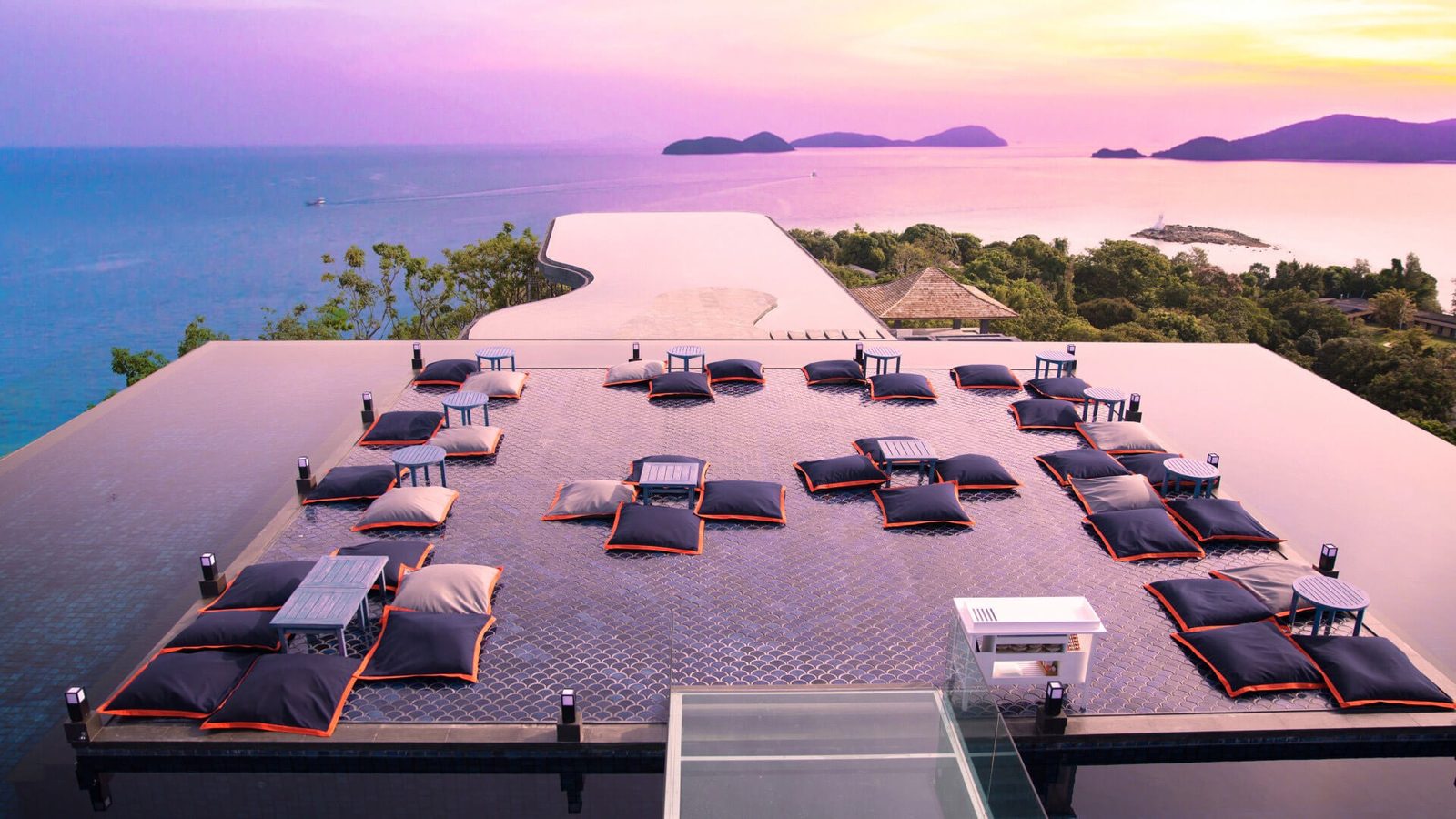Baba Nest rooftop bar at Sri Panwa Phuket at sunset, with floor cushions and island views