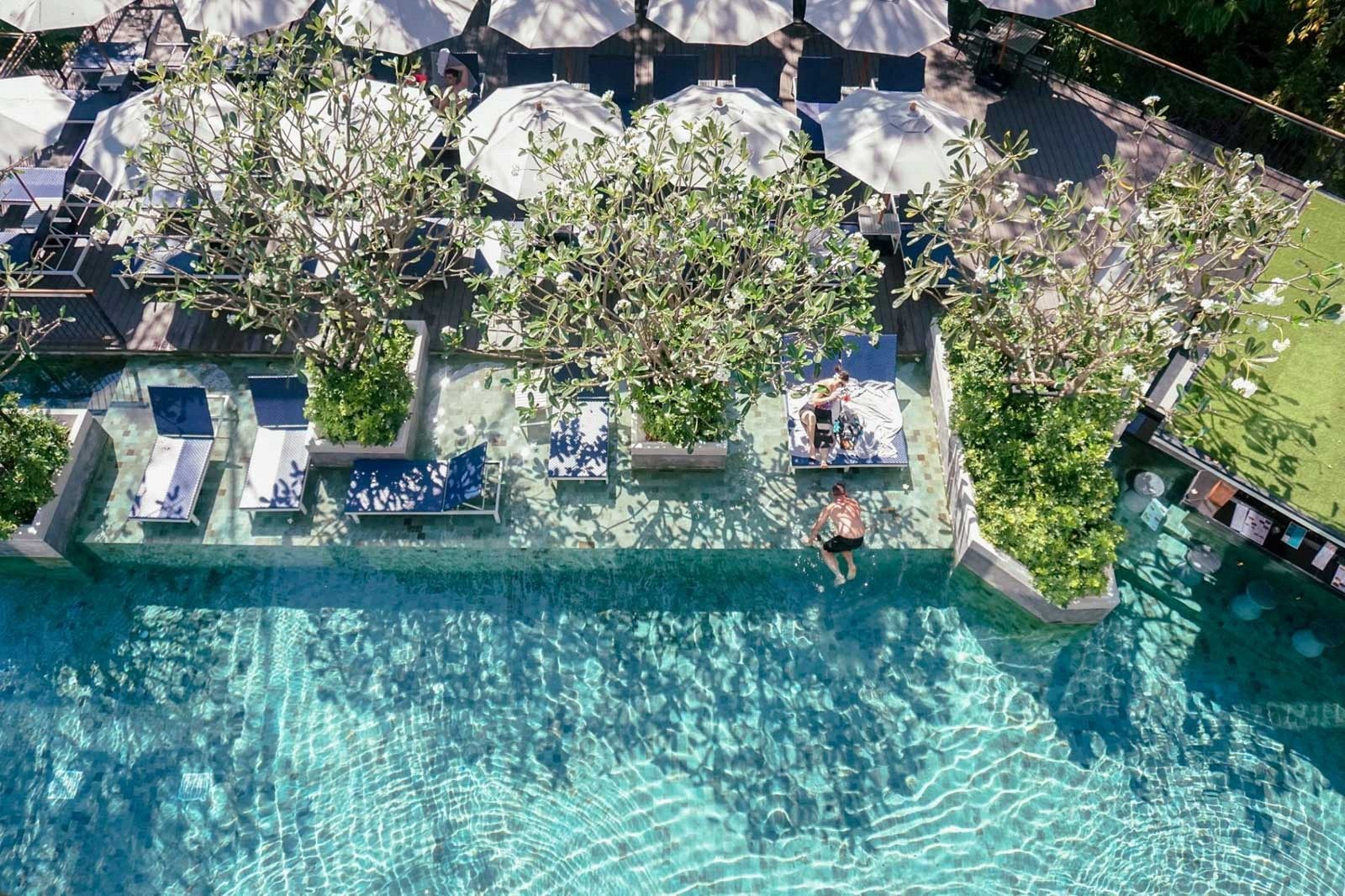 Overhead view of a pool with loungers among trees at The Nature Phuket