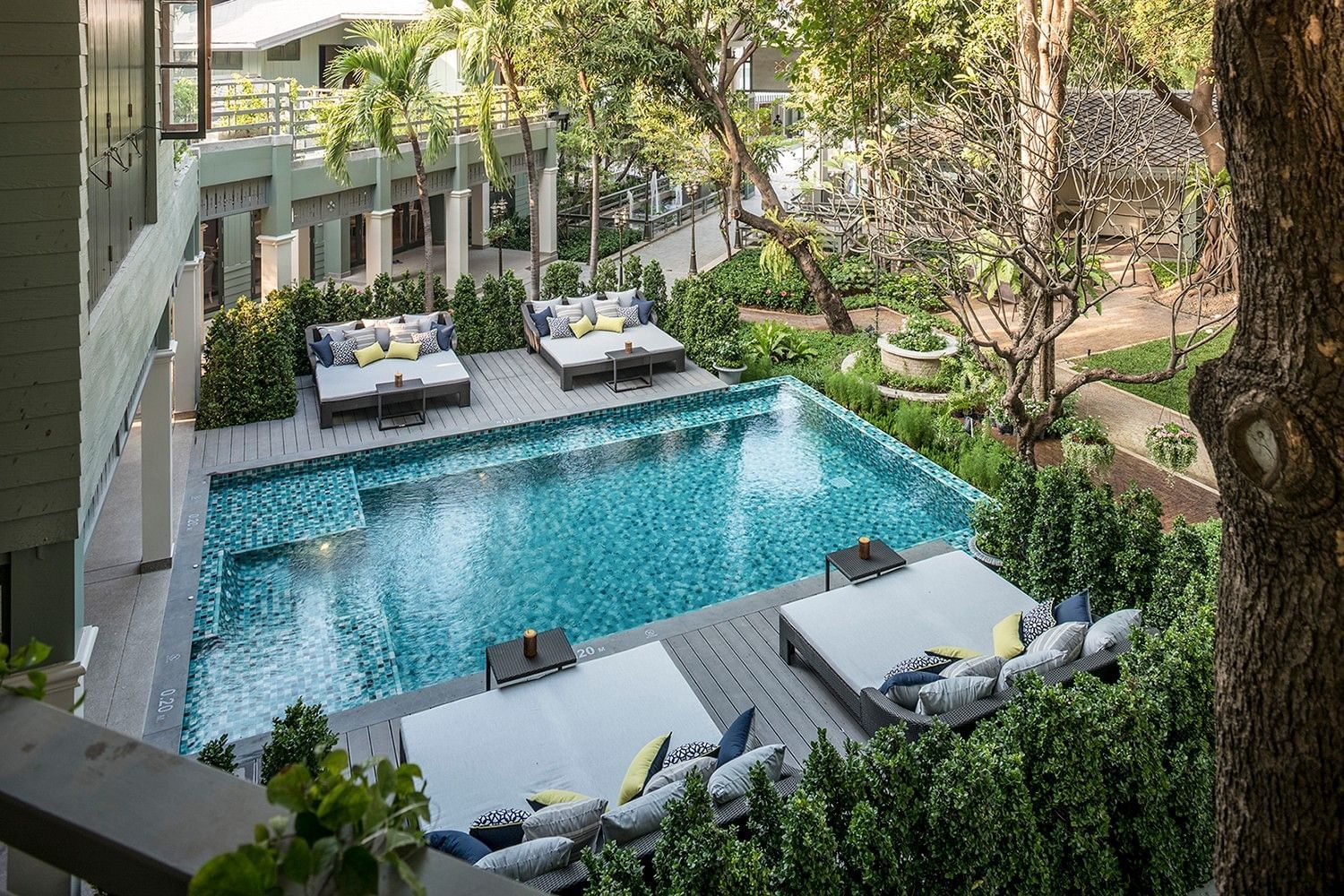 Swimming pool with sun loungers and garden at The Raweekanlaya Bangkok, seen from above