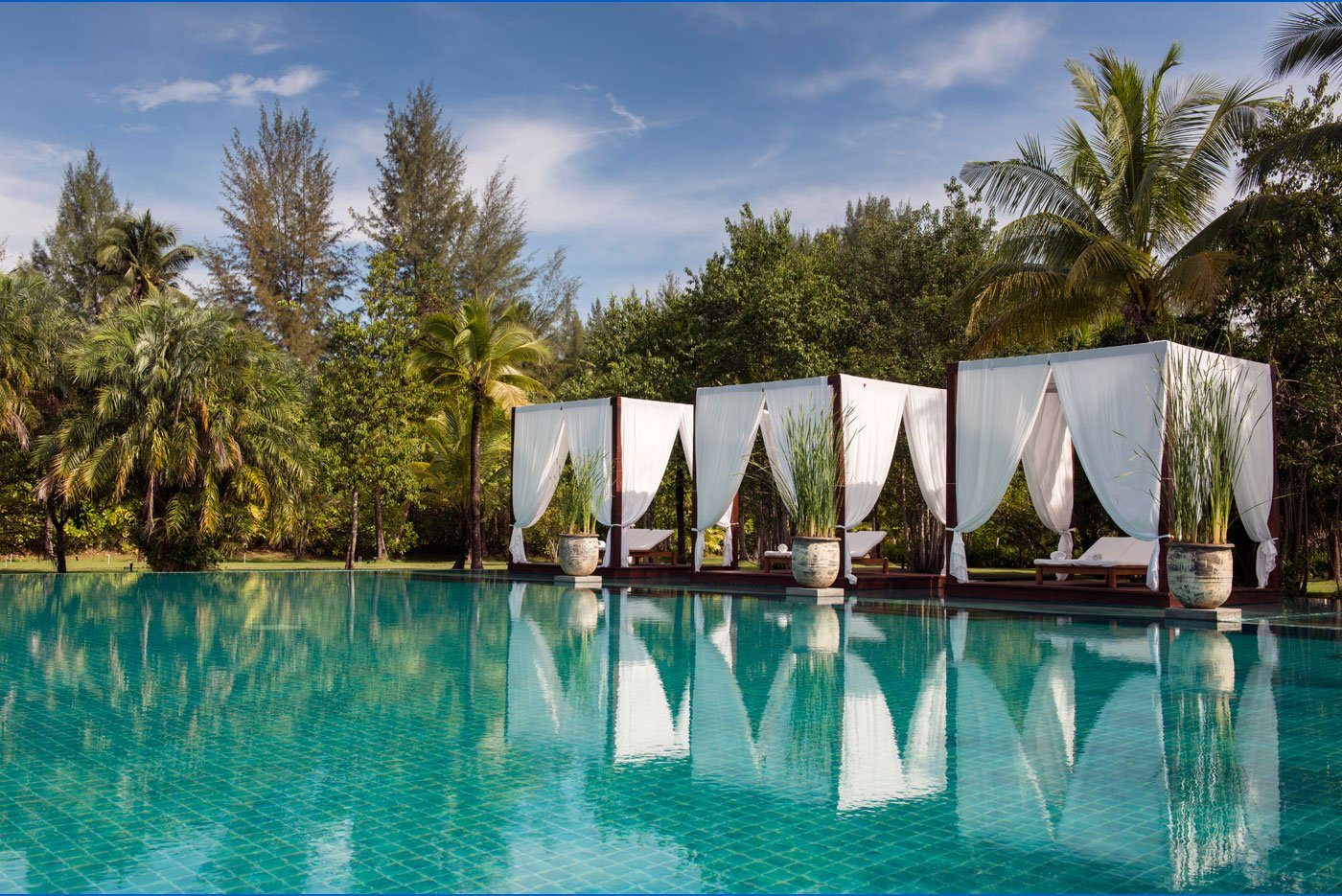 Swimming pool with white-curtained floating pavilions at The Sarojin, Khao Lak
