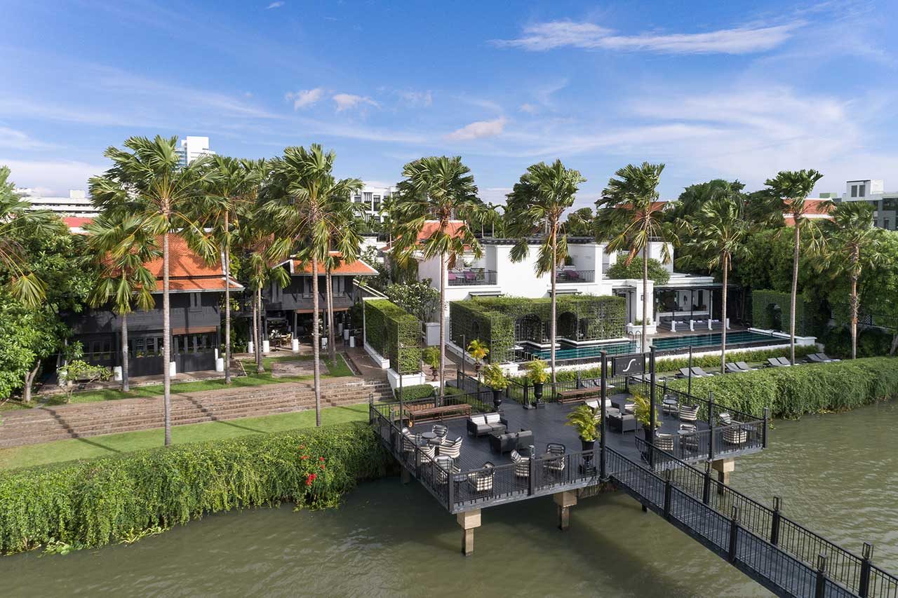 Aerial view of The Siam's riverfront with its pier, teak houses and pool on the Chao Phraya