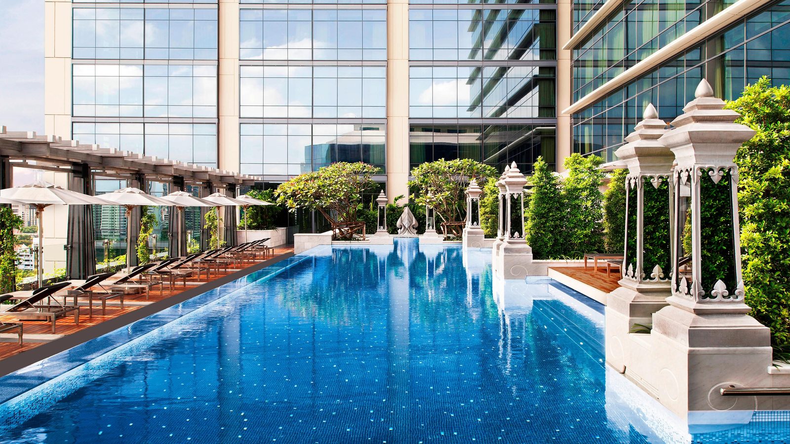 Outdoor pool with Thai-style pavilions and loungers at The St. Regis Bangkok